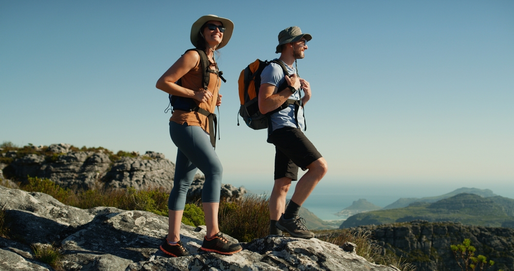 Two hikers with backpacks taking in the view on a mountain ridge