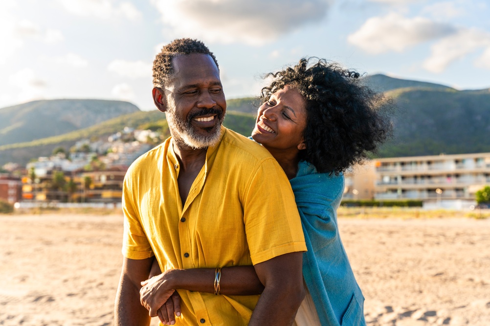Older couple laughing together on the beach