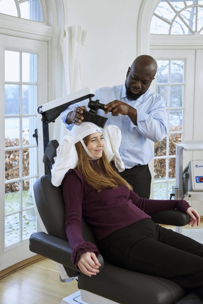 Provider positioning the TMS coil before a treatment session